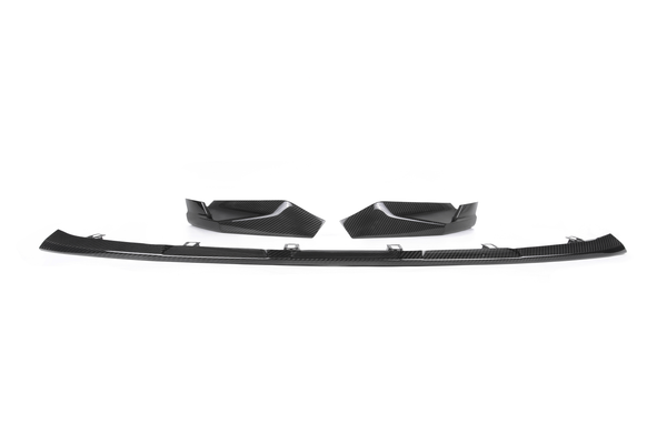 A set of black carbon fiber car parts, including a split lip spoiler and two corner extensions, displayed on a plain white background.