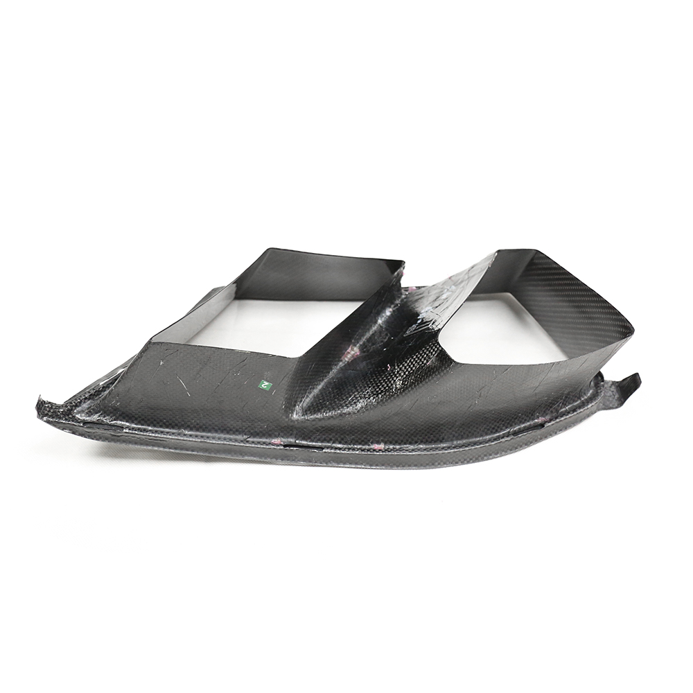 Black carbon fiber panel with angular, aerodynamic design; rests on a flat surface, showcasing its lightweight structure and modern engineering.