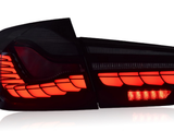 A red LED tail light glows brightly, revealing angular, layered patterns. It is against a plain white background, emphasizing its sleek, modern design.