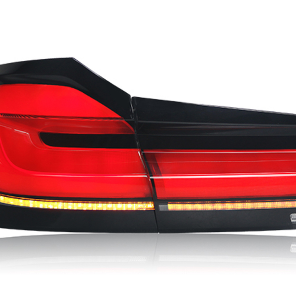 A sleek, modern car taillight with red, black, and amber segments, set against a white background, displaying sharp geometric lines and reflective surfaces.