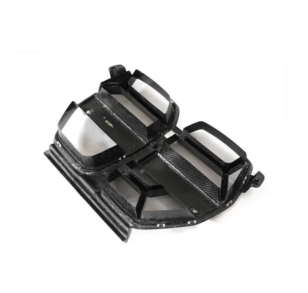 Carbon fiber car grille with angular slats, designed to replace the original grille, lies on a white surface. Top text: "Replace the original grill. Direct Screw On."