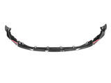 Carbon fiber car front splitter with aerodynamic design, featuring red accents and mounting points. It is placed against a plain white background.