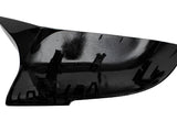 A shiny black plastic car mirror cover, angled with multiple clips visible on the interior, set against a plain white background.