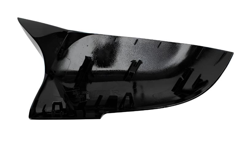 A shiny black plastic car mirror cover, angled with multiple clips visible on the interior, set against a plain white background.