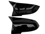 Two sleek black car side mirror covers are displayed horizontally against a plain white background. The covers have a glossy finish and aerodynamic design, suggesting a modern style.