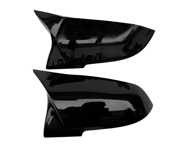 Two sleek black car side mirror covers are displayed horizontally against a plain white background. The covers have a glossy finish and aerodynamic design, suggesting a modern style.