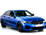 A blue sedan with sleek, aerodynamic design and black alloy wheels, rests on a glossy white background, highlighting its modern sporty features. No text present.