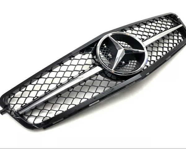 A black car grille features a central silver emblem with three pointed stars, bordered by a mesh pattern against a plain white background.