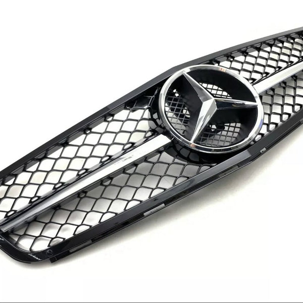 A black car grille features a central silver emblem with three pointed stars, bordered by a mesh pattern against a plain white background.