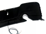 A black car bumper with sectioned panels and an extended wire sits against a plain white background.
