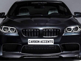 The car is a sleek black sedan with illuminated headlights facing forward. Text on the front reads 