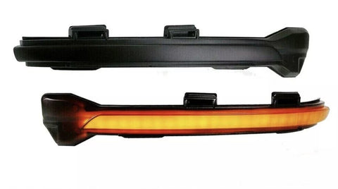 Two black automotive light fixtures are shown. The top fixture is unlit, while the bottom fixture emits a continuous amber glow. Both have mounting brackets and are isolated on a white background.