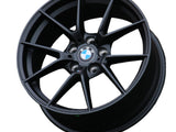 A black BMW wheel rim, featuring a multispoke design with the BMW logo at the center, is set against a plain white background.