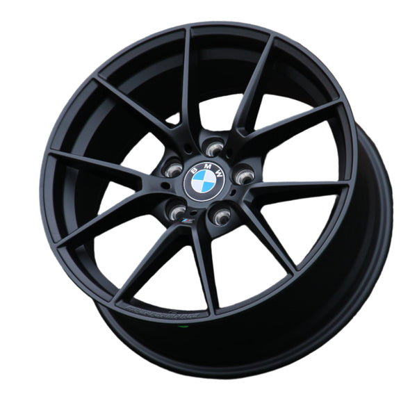 A black BMW wheel rim, featuring a multispoke design with the BMW logo at the center, is set against a plain white background.