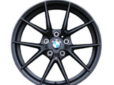 A black BMW car wheel rim with a multi-spoke design showcases the BMW logo at the center. Text includes 