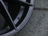 The black alloy wheel, featuring the text 