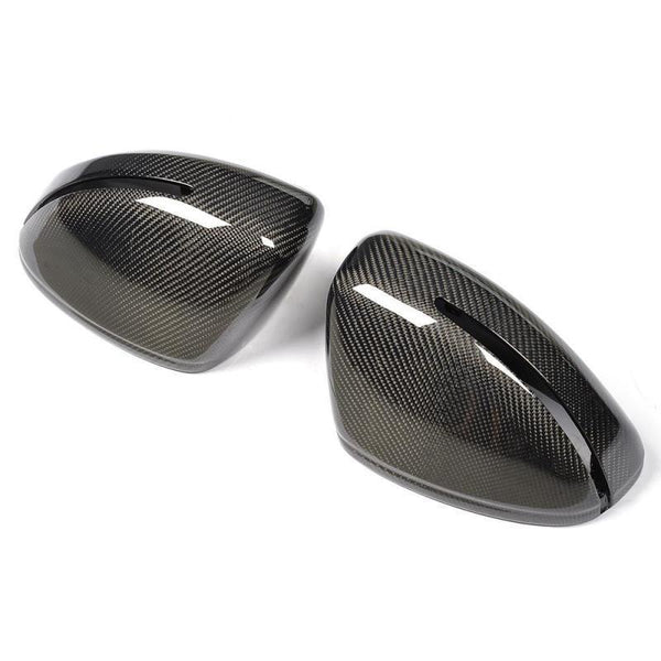Two black carbon fiber car mirror covers with a sleek, glossy finish, positioned side by side, against a plain white background.