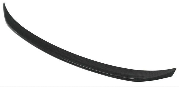 A black, curved car spoiler made of carbon fiber material is displayed against a plain white background.