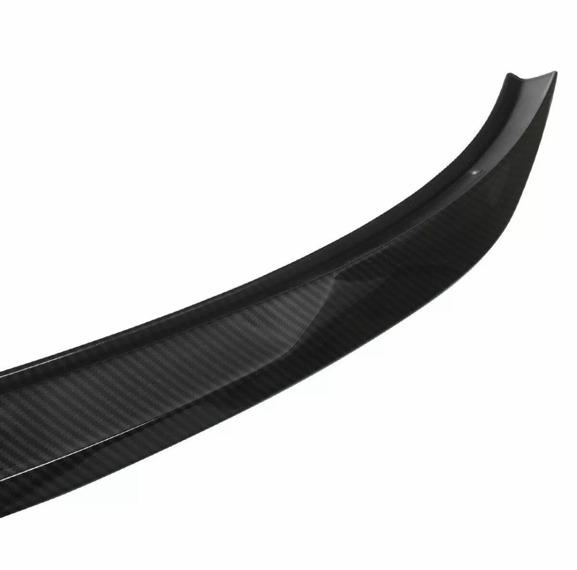 Curved carbon fiber car spoiler, resting on a plain white background, displaying a sleek design and a glossy surface texture.