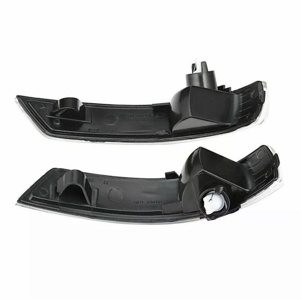 Two black car mirror indicators, each with a sleek curved shape and mounting clips, lie against a white background, showcasing their design and structure for automotive use.
