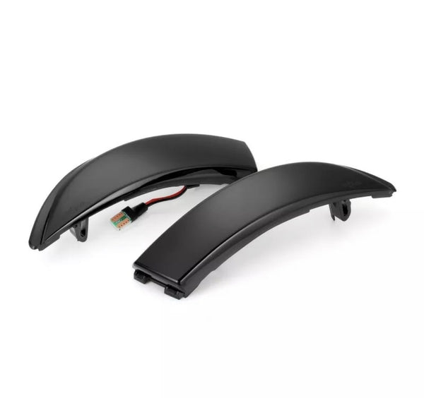 Two black curved LED indicator lights rest on a white background, each featuring a connected wire and plug, designed for automotive or motorcycle use as signal lights.