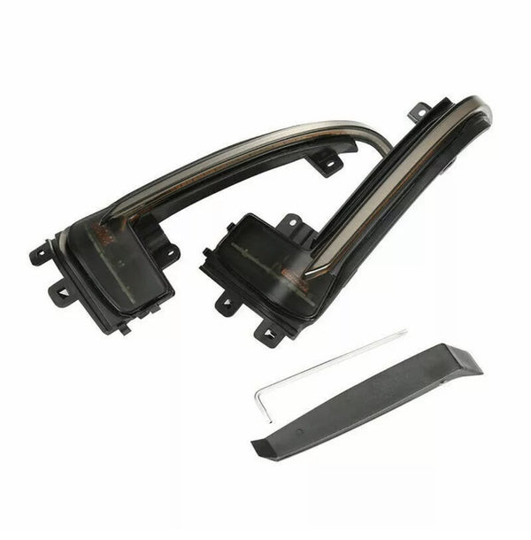 Curved, black plastic automotive parts with mounting brackets sit on a white background. A thin metal rod and a separate flat black piece accompany the main components, suggesting car accessory assembly.