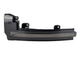 A black car component, possibly a side mirror turn signal cover, is displayed on a plain white background, featuring mounting brackets and a sleek, curved design.