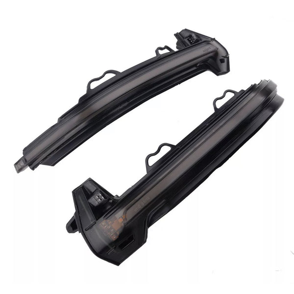 Two curved black plastic car mirror covers with integrated LED turn signals lie against a plain white background, showcasing openings and connectors for installation.