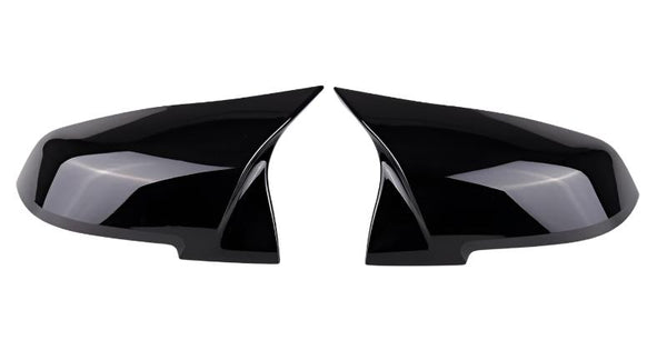 Two black, glossy side mirror covers are positioned symmetrically, facing each other against a plain white background.
