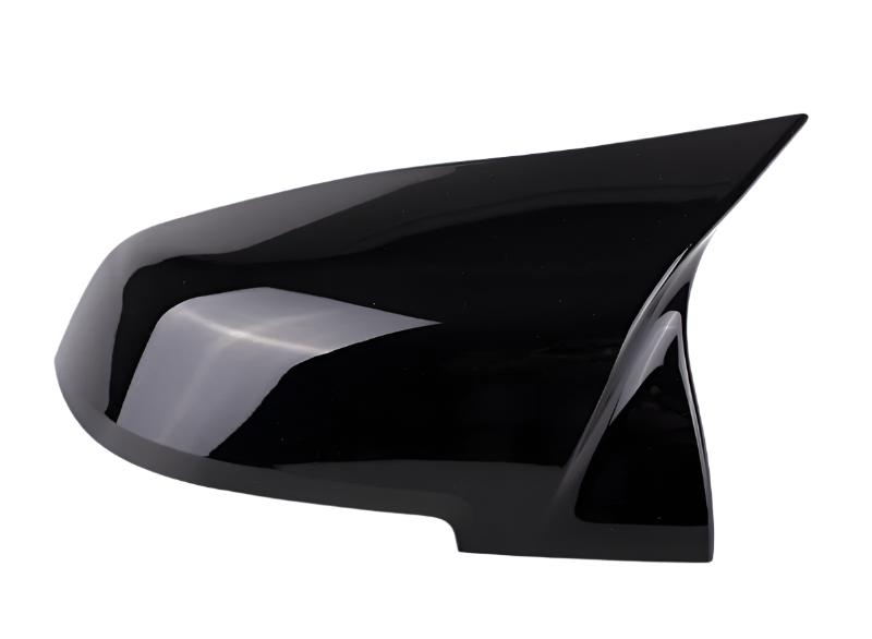 A sleek black car side mirror cover with a pointed design, resting on a white background, reflecting light slightly.