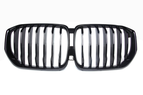 A shiny black car grille with vertical slats, forming two adjacent kidney-shaped sections, set against a plain white background.