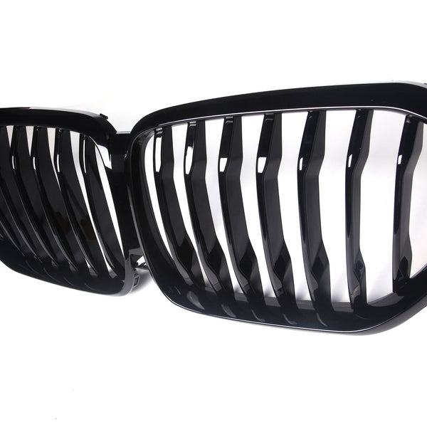 A black grille with vertical slats is positioned side-by-side, designed for a vehicle's front. It is set against a plain white background, emphasizing its shiny finish.