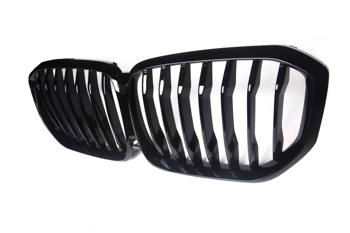 A black grille with vertical slats is positioned side-by-side, designed for a vehicle's front. It is set against a plain white background, emphasizing its shiny finish.