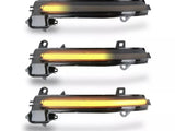 Three sequentially lit amber LED strips, mounted in black plastic casings, appear aligned vertically against a white background; they resemble automotive indicator lights.