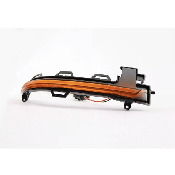 A curved, amber-colored car indicator light with plastic mounting brackets rests on a white background, featuring attached wiring for electrical connection.