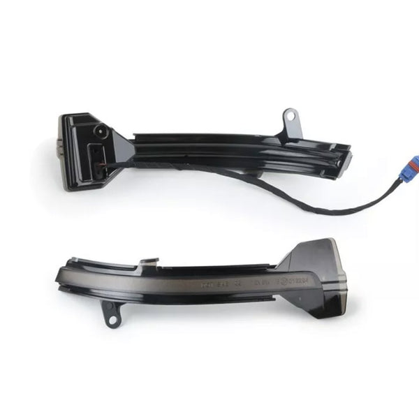 Two black, curved plastic car mirror indicators, one with an attached cable and connector, lie on a white background. They are designed to fit onto the side mirrors of a vehicle.