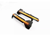 Two sleek, black-and-orange automotive parts with integrated wiring lie on a plain white surface, likely designed as LED light strips or indicators for vehicle installation.