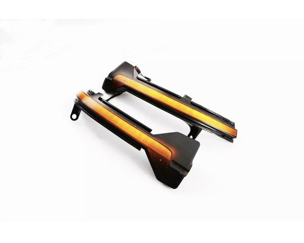 Two sleek, black-and-orange automotive parts with integrated wiring lie on a plain white surface, likely designed as LED light strips or indicators for vehicle installation.