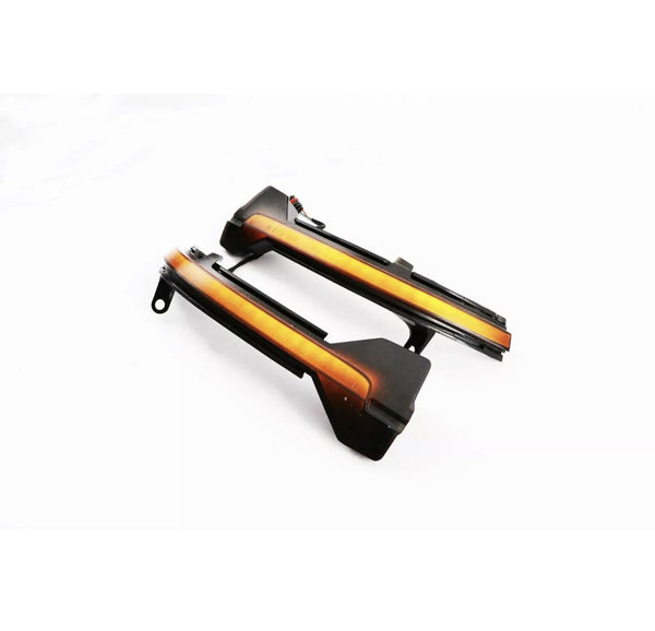 Two sleek, black-and-orange automotive parts with integrated wiring lie on a plain white surface, likely designed as LED light strips or indicators for vehicle installation.