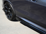 Car door with glossy black trim and wheel, parked on a smooth asphalt surface in sunlight.