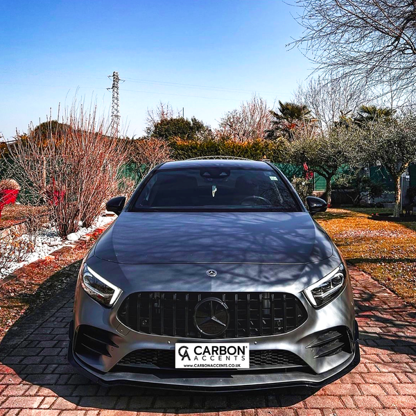 A gray car is parked on a brick driveway, surrounded by winter trees and dry grass. Text reads: "CARBON ACCENTS" and “WWW.CARBONACCENTS.CO.UK.”