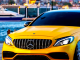 A yellow Mercedes-Benz car is parked near a waterfront with a city skyline in the background, including distant buildings and a boat on the water.
