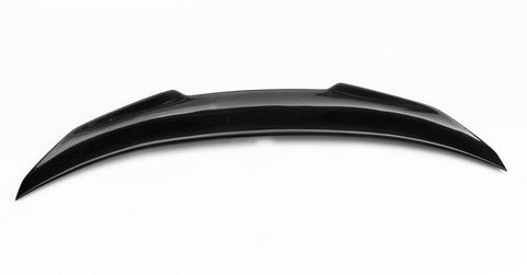 A sleek, black carbon fiber car spoiler with a curved, aerodynamic design rests against a plain white background.