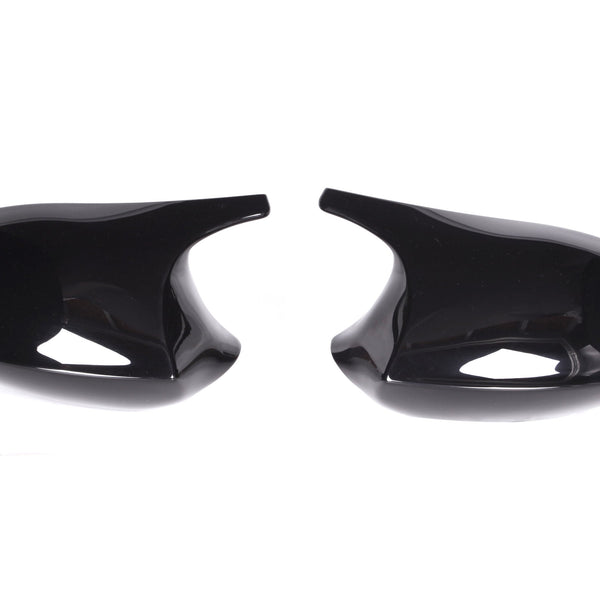 Two glossy black mirror covers face each other on a plain white background, showcasing their curved, sleek design ideal for vehicle customization.