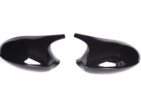 Two glossy black side mirror covers facing each other on a white background, with a sleek, curved design.