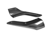 Two black carbon fiber automotive parts are placed on a white background. Text on one part reads 