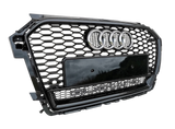 A car grille displays the Audi logo and "quattro" text in a hexagonal pattern with a glossy black finish, positioned against a light gray textured background.