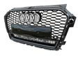 A black car grille with a honeycomb pattern, featuring four chrome rings and "quattro" text, is displayed against a plain background.