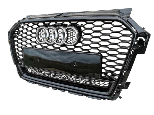 A black car grille with a honeycomb pattern, featuring four chrome rings and "quattro" text, is displayed against a plain background.