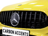 A yellow car's front grille features a prominent emblem and vertical bars. Below, a license plate reads 
